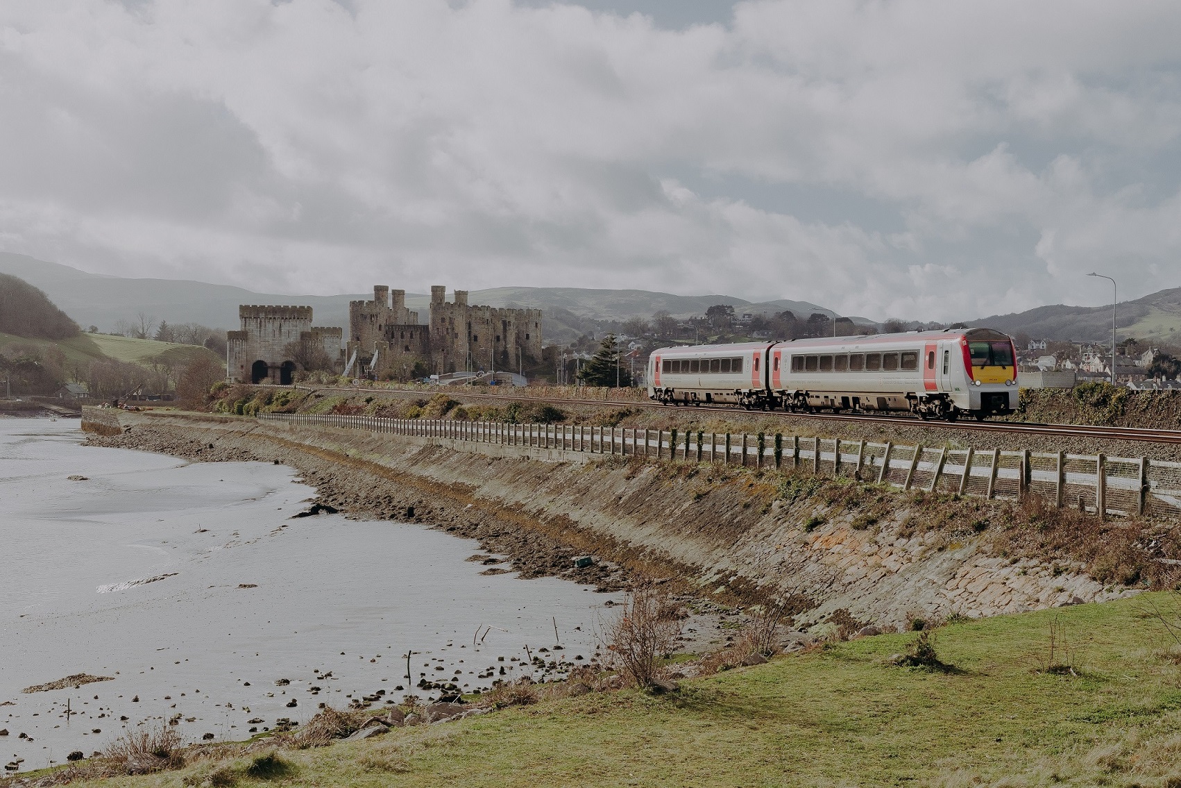 Train on tracks passing Conwy Castle
